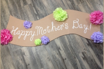 Mother's Day | Party | Cute Banner Idea | Mother's Day Decor | This easy to make banner adds a pretty festive look. Make it for Mother's Day or any other special holiday. It's cheap to make, too. Six Clever Sisters has an easy tutorial on making the banner as well as the tissue paper flowers.