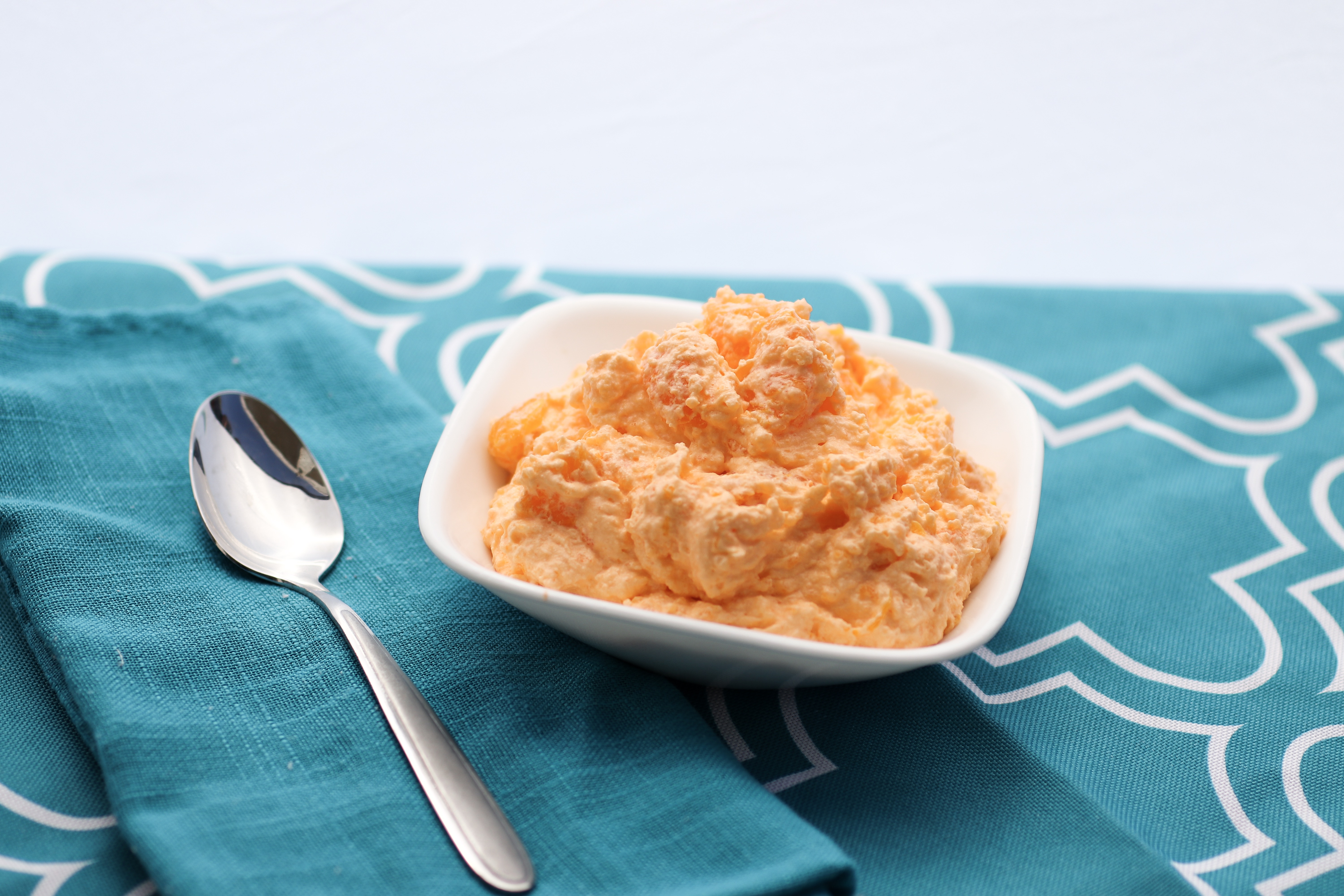 Creamy Orange Dreamsicle Dessert | Orange Creamsicle | Orange Dessert | Creamsicle Recipe | Orange Fluff | Orange Fluff Recipe | Fluffy Orange Dessert | No Bake Recipe | This Creamy Orange Dreamsicle Dessert is such a yummy and easy dessert! It's great for any summer get-together . . . and it doesn't require any baking! Find the recipe at SixCleverSisters.com