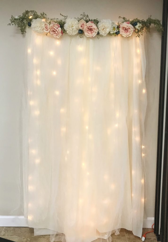 How to Make a Wedding Backdrop | DIY Lit Tulle Backdrop | Bridal | Wedding | Bridal Shower | Wedding Shower | Photography Backdrop | Floral Decor | Backdrop | Background | Bride | Bride to Be | Wedding Shower Ideas | Shower on a Budget | Baby Shower | Simple Decorating Ideas | Easy Decor | Quick tutorial on Six Clever Sisters!