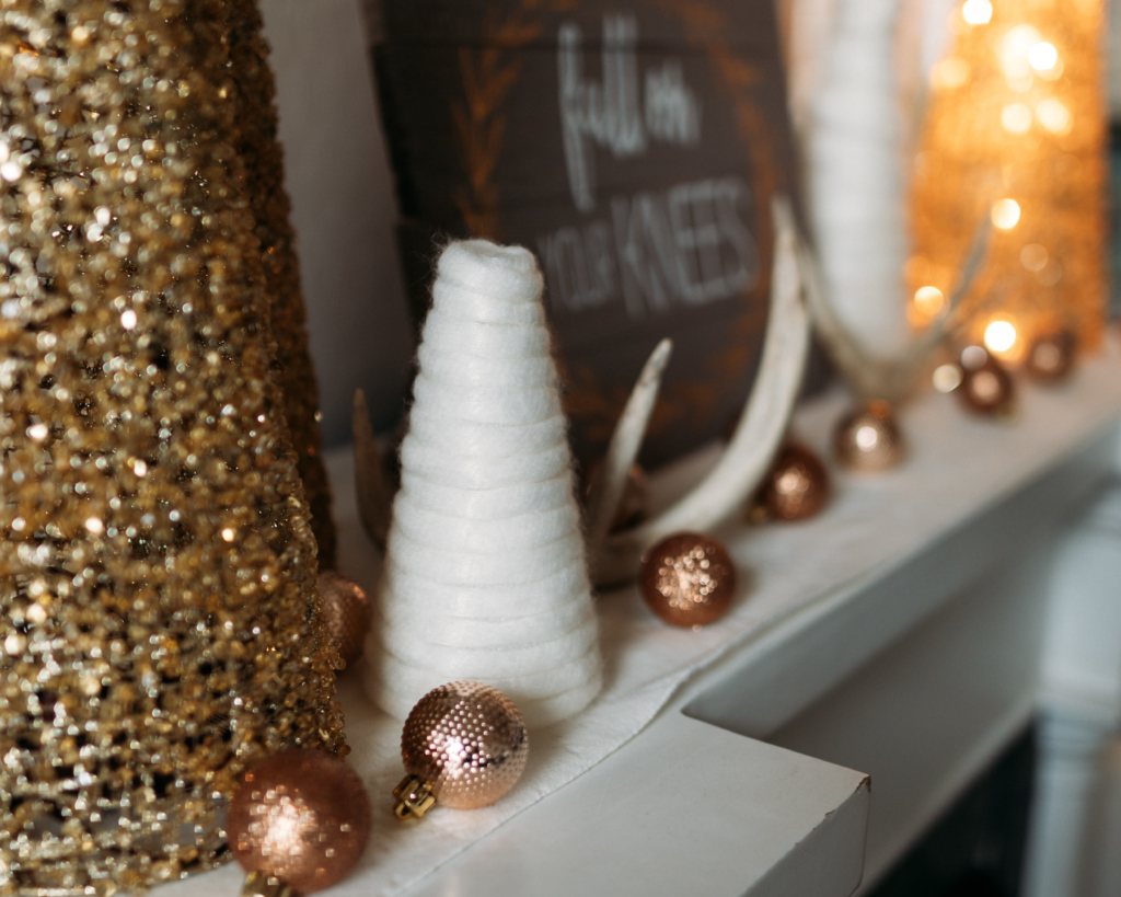 Holiday Decor | Christmas Mantle | Mantlescape | Winter Mantle | Elegant Mantlescape | Gold and White Mantle Decor | Gorgeous DIY mantle scape for winter with gold and white trees. Find the tutorial for the yarn-wrapped trees at SixCleverSisters.com.